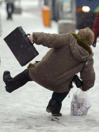 Photo d'une personne qui glisse sur un trottoir enneigé